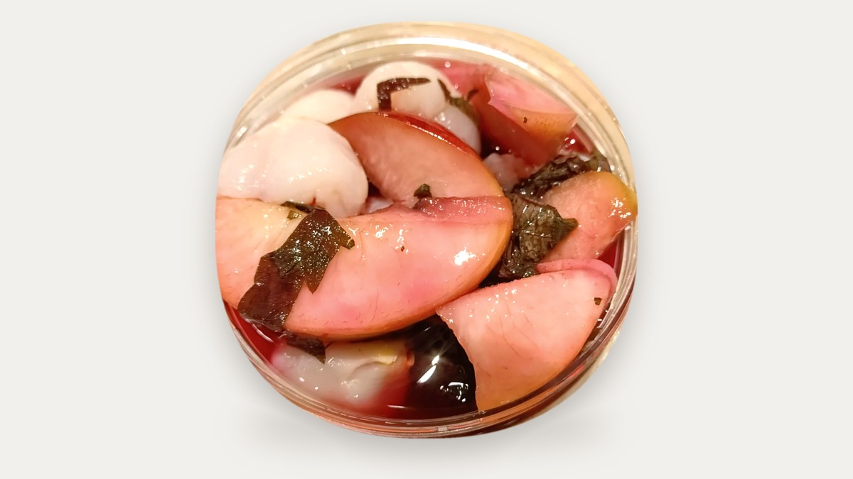 Frozen Perilla Peach: peach slices and perilla (shiso) leaves in red peach juice in a clear jar