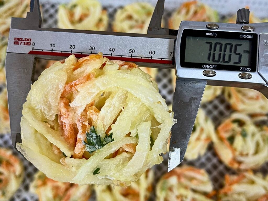 Quality check: measuring an IQF mixed vegetable patty with a digital caliper
